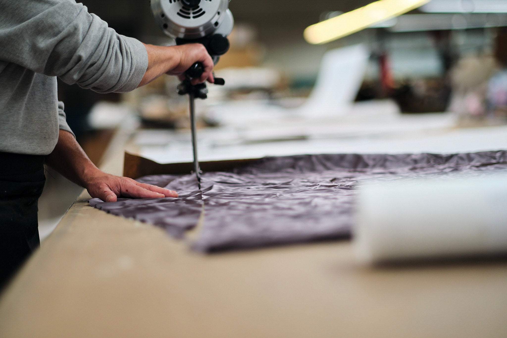 Someone using an industrial fabric cutter.
