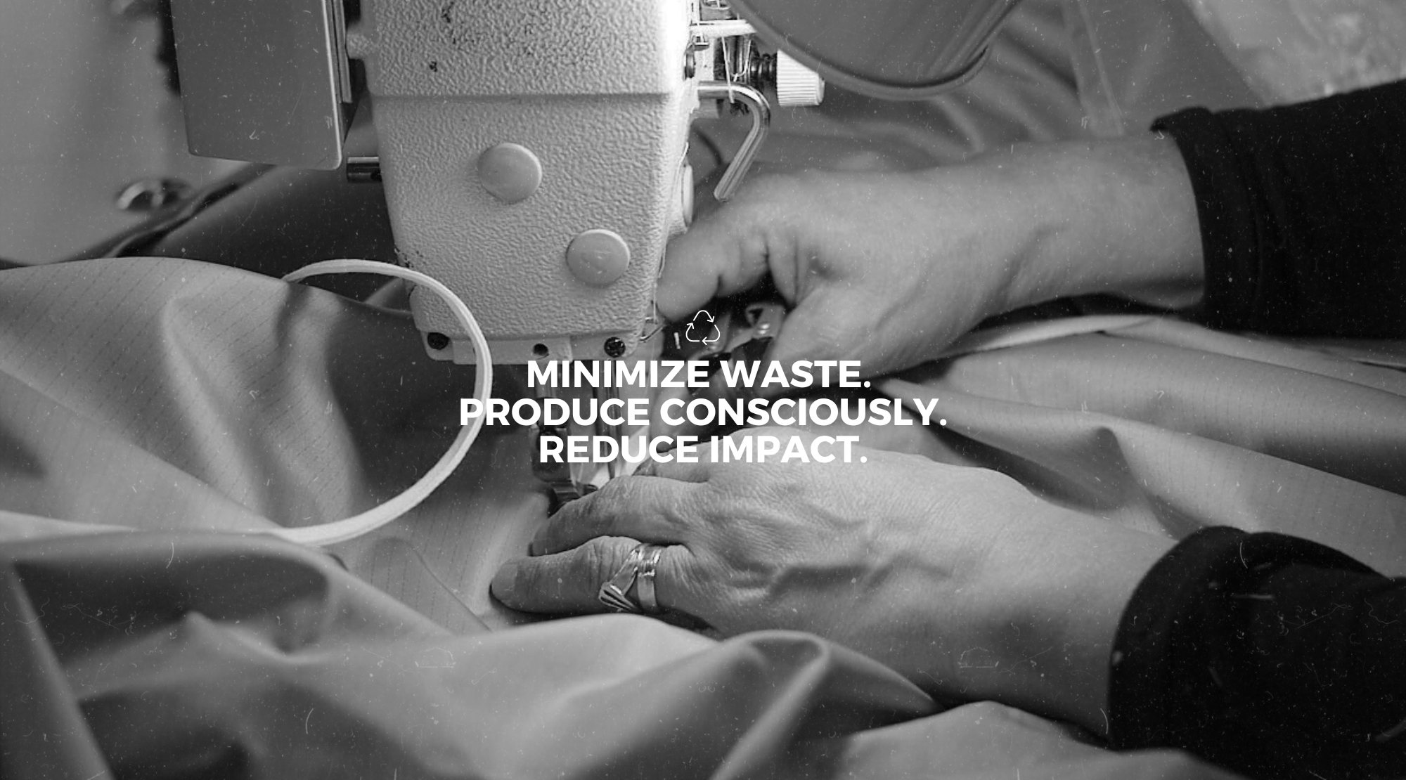 Black and white close-up of a sewing machine in use.