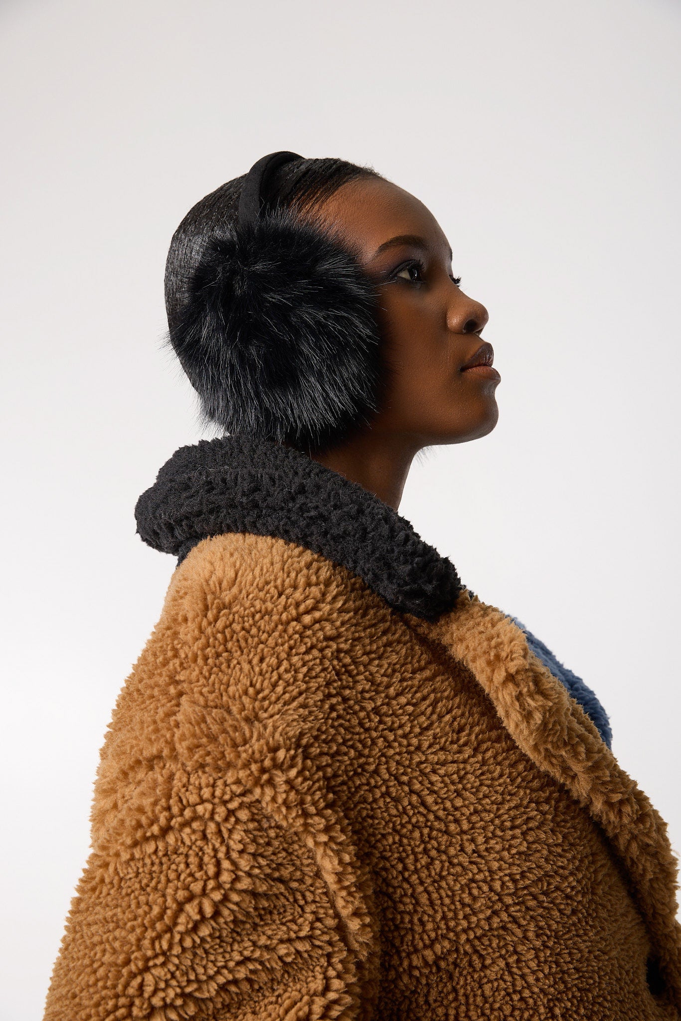 Editorial/detail shot — Ear Muffs in Ink Black styled on a model, highlighting the soft texture and sleek black colour as a cozy winter accessory.