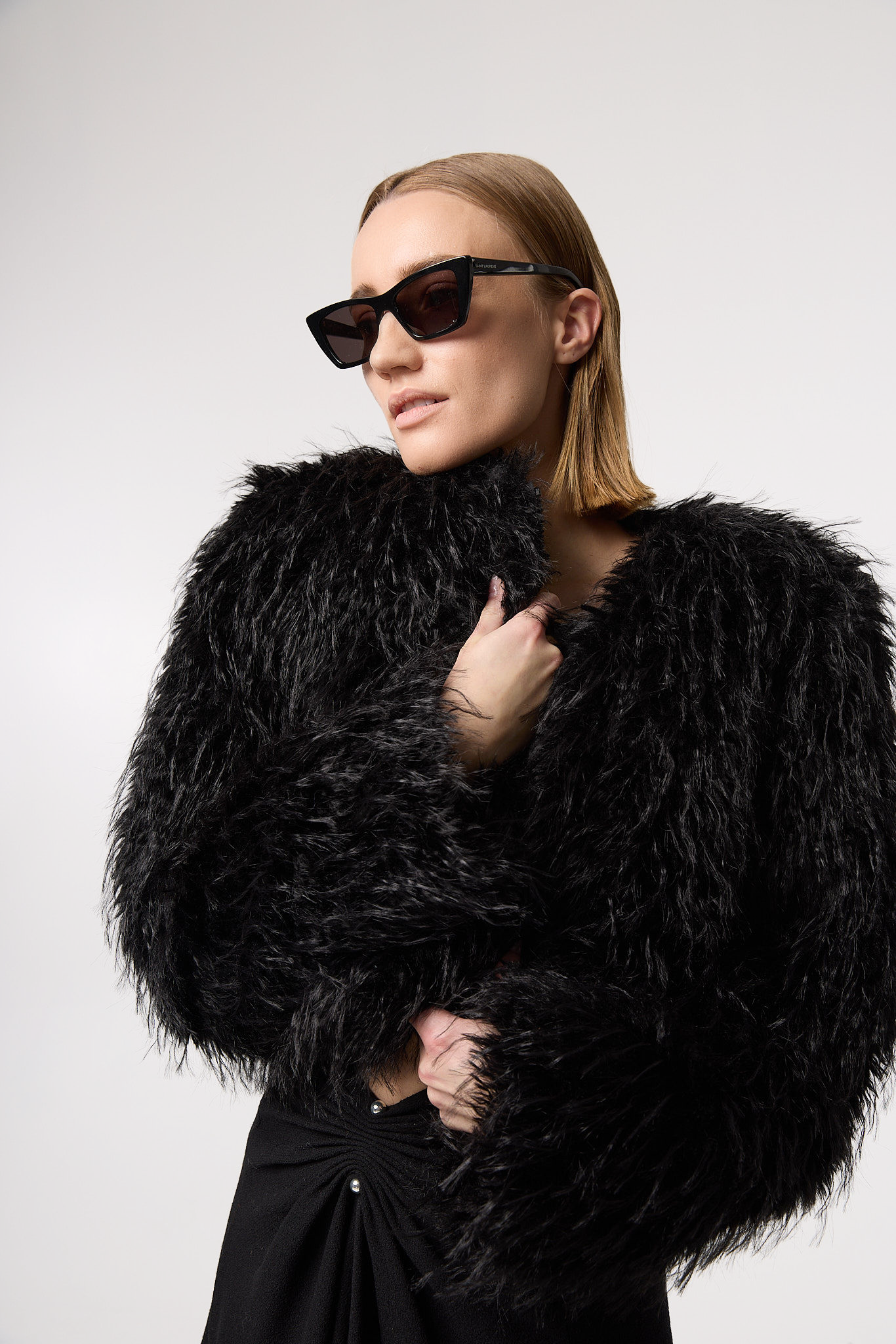 ANNA jacket in Carbon — styled in motion for a campaign shot, showcasing bold cropped silhouette and luxury faux fur.