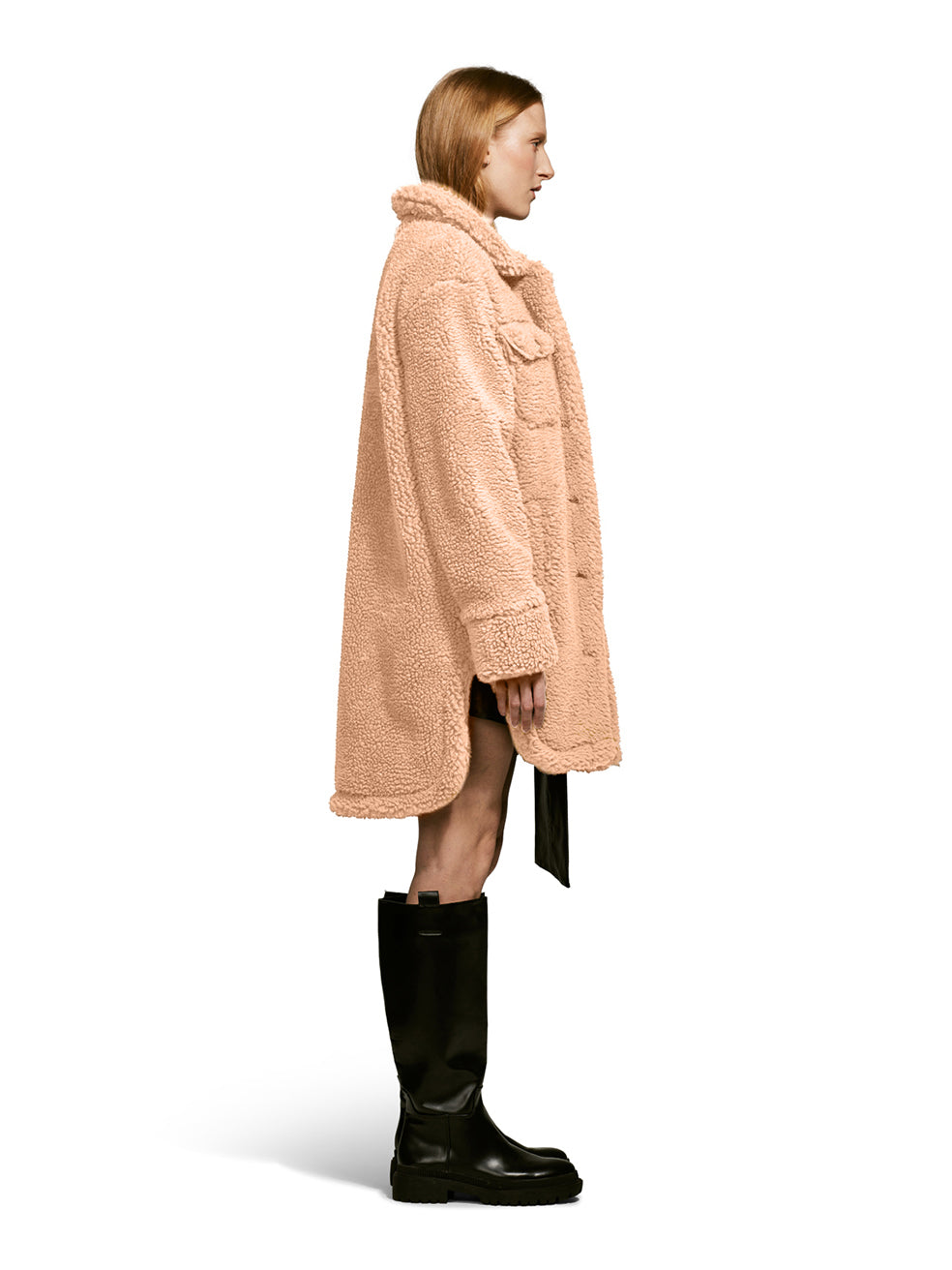 Model wearing the Ash, a teddy-inspired faux-fur sherpa shell with a laid-back silhouette in Camel from the Side.