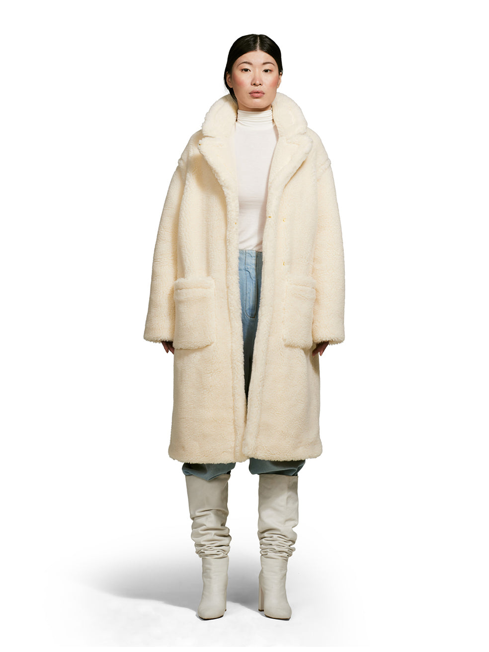 Model wearing a teddy-inspired faux-fur sherpa shell in cream color on a white background from the front.